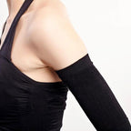 Person wearing a black arm sleeve on one arm against a white background