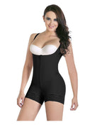 Woman wearing a black shapewear romper with a white bra on a white background