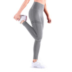 Person wearing gray leggings and white sneakers on a white background