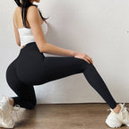 Person wearing black leggings and white sneakers, performing a lunge against a light-colored wall.