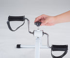 Hand using a manual exercise device on a light gray background