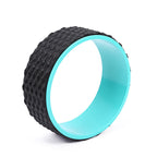 Black textured exercise wheel with a turquoise rim on a white background