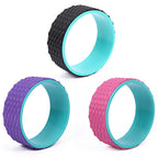 Three colorful exercise wheels with textured surface on a white background