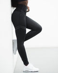 Person wearing black leggings and white sneakers on a white background