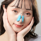 Woman with blue nose clips on a neutral background