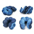 Set of four blue and navy knotted neck pillows on a white background