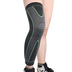 Black and green knee brace on a person's leg against a white background