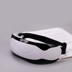 White eye massager with black straps on a gray background