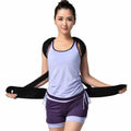 Woman wearing a black back brace on a white background