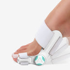 Foot with a white bunion corrector on a light gray background